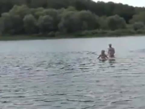 Couple baise sur la plage devant leurs amis